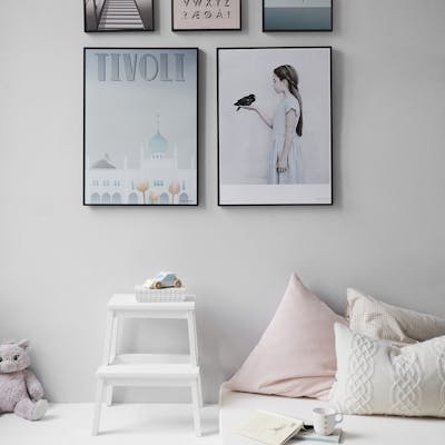 Minimalist Scandinavian bedroom with wall art and cozy decor elements.